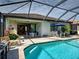 Relaxing screened-in pool area with comfortable seating and a refreshing blue umbrella at 13862 Miranese St, Venice, FL 34293