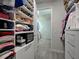 Organized walk-in closet with shelving, drawers, and ample storage space with tile flooring at 13862 Miranese St, Venice, FL 34293