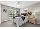 Cozy bedroom with a ceiling fan, large window, soft carpet, and a comfortable bed at 2396 Caraway Dr, Venice, FL 34292