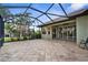 Screened-in patio with brick pavers, ceiling fan, and view of the landscaped backyard at 2396 Caraway Dr, Venice, FL 34292