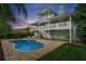 Beautiful backyard with pool, lush landscaping, outdoor seating, and a multi-story home at 334 7Th N Ave, Tierra Verde, FL 33715