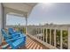 Outdoor balcony features partial sun, views of greenery, and comfortable blue Adirondack chairs at 334 7Th N Ave, Tierra Verde, FL 33715