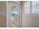 A door leads out to a wooden porch with white railing from a room with a shuttered window at 334 7Th N Ave, Tierra Verde, FL 33715