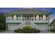 Charming two-story home with a double staircase, white railings, and a well-maintained landscaped yard at 334 7Th N Ave, Tierra Verde, FL 33715