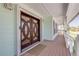 Inviting front entrance with detailed wood door, sidelights, and a spacious covered porch at 334 7Th N Ave, Tierra Verde, FL 33715
