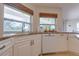 Granite countertops and white cabinetry surround a stainless steel sink under a window with bamboo blinds at 334 7Th N Ave, Tierra Verde, FL 33715