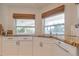 Well-lit kitchen showcasing granite countertops, white cabinets, and windows with natural light at 334 7Th N Ave, Tierra Verde, FL 33715