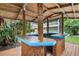 Outdoor tiki bar area with a stylish counter, bamboo accents, and views of the lush backyard at 334 7Th N Ave, Tierra Verde, FL 33715