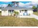 Charming single-story home featuring a well-maintained lawn and welcoming entrance with seating at 7585 Kavanda St, North Port, FL 34287