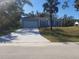 Charming single-story home featuring a wide driveway, manicured lawn, and a blue exterior at 16029 Arcaro Ave, Port Charlotte, FL 33954
