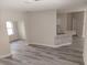 Bright living room with modern gray flooring and a glimpse of the kitchen featuring a stylish marble countertop at 16029 Arcaro Ave, Port Charlotte, FL 33954