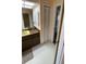 Bathroom features a bright vanity, mirror, and tiled floors, adjacent to a closet for storage at 4250 Shamrock Dr, Venice, FL 34293