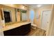 Bathroom showcasing a double sink vanity, large mirrors, toilet, and linen cabinet at 4250 Shamrock Dr, Venice, FL 34293