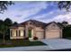 Charming single-story home with stone accents, a well-manicured lawn, and a two-car garage with a sidewalk at 25497 Calusa Dr, Punta Gorda, FL 33955