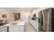 Modern kitchen featuring white cabinets, stainless steel appliances, marble countertops, and an eat-in island at 25497 Calusa Dr, Punta Gorda, FL 33955