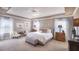 A serene and spacious main bedroom features soft lighting, tray ceilings, neutral decor, and large windows at 25497 Calusa Dr, Punta Gorda, FL 33955