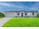 Inviting single story home with large green front lawn, two-car garage and covered porch at 15245 Brainbridge Circle, Port Charlotte, FL 33981