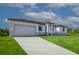 Driveway and well-manicured lawn lead to a contemporary single Gathering home with an attached garage at 15245 Brainbridge Circle, Port Charlotte, FL 33981