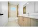 Modern bathroom with wood vanity, bathtub and marble-look tile at 15245 Brainbridge Circle, Port Charlotte, FL 33981