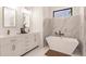 Elegant bathroom with double vanity, soaking tub, and marble tile at 24194 Peppercorn Rd, Punta Gorda, FL 33955