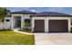 Modern home with a two car garage and a landscaped lawn at 24194 Peppercorn Rd, Punta Gorda, FL 33955