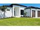 Modern home with a two car garage and a manicured lawn at 24194 Peppercorn Rd, Punta Gorda, FL 33955