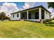White house with screened patio and lush landscaping at 24194 Peppercorn Rd, Punta Gorda, FL 33955
