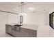 Open concept kitchen with gray island and stainless steel sink, flows into the living area at 24194 Peppercorn Rd, Punta Gorda, FL 33955