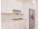 Modern kitchen features white cabinets and stainless steel appliances at 24194 Peppercorn Rd, Punta Gorda, FL 33955