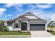 Modern one-story home with gray garage door and stone accents at 25491 Calusa Dr, Punta Gorda, FL 33955