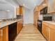 Modern kitchen with wood cabinets, granite countertops, and black appliances at 865 Everest Rd, Venice, FL 34293