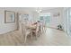 Bright dining room with large window, modern chandelier and seating for eight at 7438 Gulf Way, Hudson, FL 34667