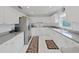 Modern, all-white kitchen featuring stainless steel appliances and granite countertops at 7438 Gulf Way, Hudson, FL 34667