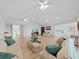 Spacious living room featuring light wood floors, ceiling fans, and comfortable seating at 7438 Gulf Way, Hudson, FL 34667