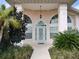 Inviting front entrance with arched windows and landscaping at 1 Long Meadow Ln, Rotonda West, FL 33947
