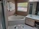 Bathroom with corner bathtub, vanity, and tiled floor at 1 Long Meadow Ln, Rotonda West, FL 33947