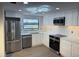 This kitchen features stainless steel appliances, white cabinets and a geometric light fixture at 12550 Capri N Cir, Treasure Island, FL 33706