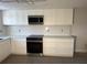 Bright kitchen features white cabinets, quartz counters, and stainless steel microwave oven at 12550 Capri N Cir, Treasure Island, FL 33706