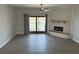 Spacious living room with modern electric fireplace and a glass sliding door to the outside at 12550 Capri N Cir, Treasure Island, FL 33706