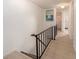 Upstairs hallway with wood-look flooring and black railing at 12550 Capri N Cir, Treasure Island, FL 33706