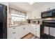 White kitchen with black appliances and granite countertops at 12550 Capri N Cir, Treasure Island, FL 33706