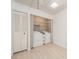 Bright laundry room with washer, dryer, and ample shelving at 12550 Capri N Cir, Treasure Island, FL 33706