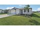 Two-car garage, gray siding, and landscaping at 14074 Ginnie Springs Way, Parrish, FL 34219