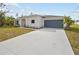 Newly built home with a light-colored exterior, two-car garage, and a paved driveway at 5255 Farmington Ave, North Port, FL 34288