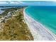 Beautiful aerial view of beachfront properties along a pristine white sandy beach, next to turquoise waters at 7442 Palm Island Dr # 3624, Placida, FL 33946