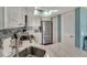 Bright kitchen features a skylight, stainless steel refrigerator, white cabinetry and mosaic tile backsplash at 7442 Palm Island Dr # 3624, Placida, FL 33946
