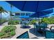Outdoor dining at Coconut's Island Rentals offers ample seating beneath large blue umbrellas and verdant tropical landscaping at 7442 Palm Island Dr # 3624, Placida, FL 33946