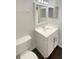 Clean, bright bathroom with a toilet and sink with dark wood-colored floors at 30208 Rattana Ct, Wesley Chapel, FL 33545