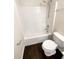 Bright white bathroom including a shower tub, toilet, and light tan walls at 30208 Rattana Ct, Wesley Chapel, FL 33545