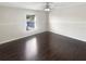 Bright and airy bedroom with wood flooring, a ceiling fan, and a large window at 30208 Rattana Ct, Wesley Chapel, FL 33545